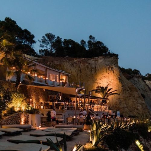 El Amante restaurant on the sea at night by a cliff in Cala Sol d'en Serra, Ibiza.