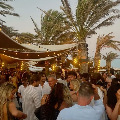 A part on the beach in Ibiza with palm trees and fairy lights in San Antonio