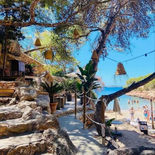 A bay in Gracioneta Cala, Ibiza with stairs and blue Mediterranean sea.