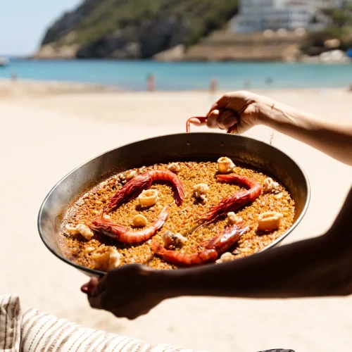 A paella being served on the beach with shrimps and squid in Santa Eulària des Riu.