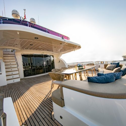 Xclusive Yacht's tri-deck superyacht with the sun setting in the background