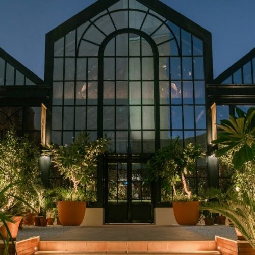 The outside of the greenhouse-like building of Eugène Eugène at night