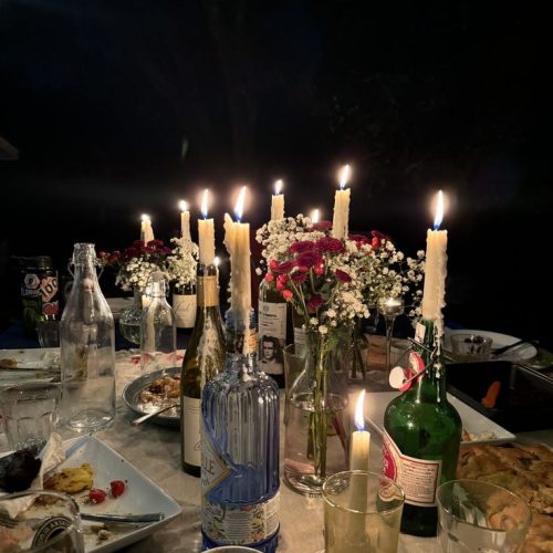The centre of a dinner party set up decorated with candles and flowers