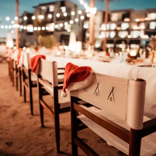 Nikki Beach festive party with Santa hats hanging from chairs and fairy lights in the background