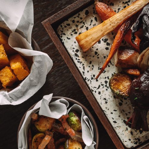 Roasted vegetables served at Piazza Italiana in side bowls and a marble plate