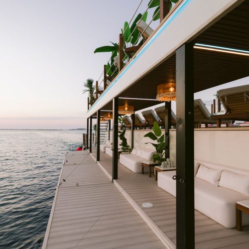 An open deck on a Odyssia Yacht decorated with deckchairs and plants