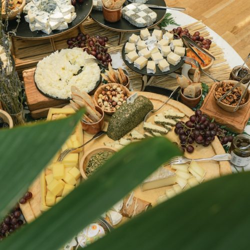 A buffet of food including breads, cheeses, grapes, and fruits at Eugène Eugène