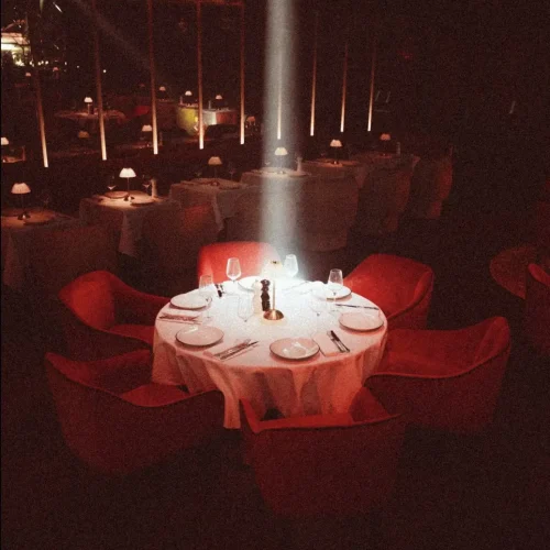 A spotlight illuminating a round table at Aretha which is set up for a dinner