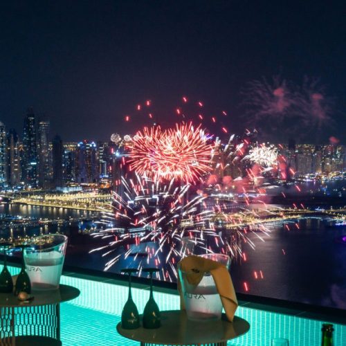 A view of fireworks from Aura Skypool with bottles of champagne and glasses