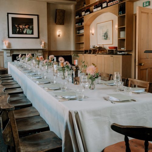 The private dining room at The Pelican set up with flowers in a long table layout