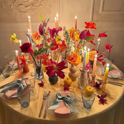 A small dinner party with colourful flowers and bows for decoration