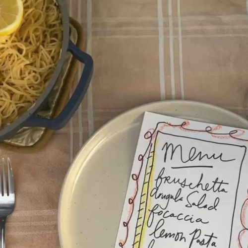 A hand-drawn menu for a dinner party set up on top of a plate