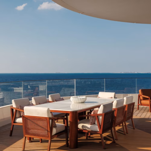A table set up on the balcony at Jumeirah Marsa Al Arab with a view of the sea in the background