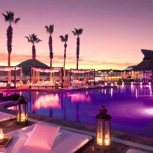 The Nikki Beach pool at sunset lit up by purple neon lights