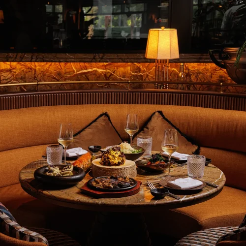 A booth table filled with food and glasses of wine at Salvaje