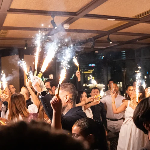A festive party at Salvaje, with guests waving sparklers in their hand