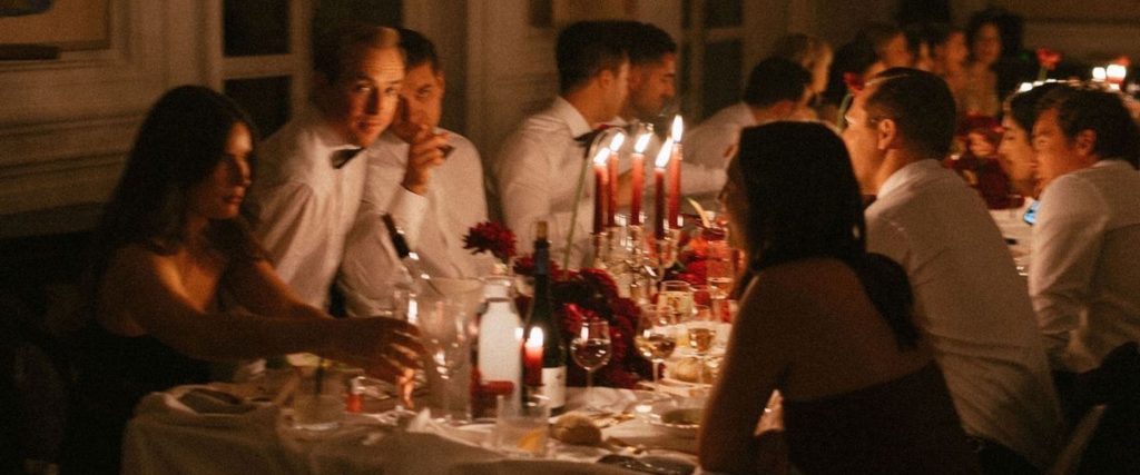 People gathered around a dinner table in a private dining room, involved in conversations
