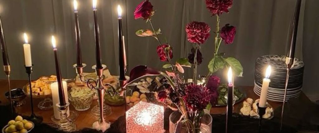 A dinner party set up with roses and long candles for ambiance
