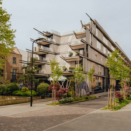 The exterior of Aethos London from the road, with trees decorating the outside