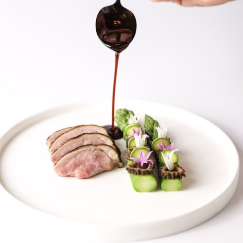 An intricate Japanese dish served at BEAR by Carlo Scotto, including a wagu steak and sauce dripping from a spoon