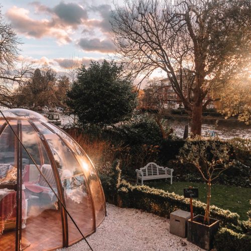 The outside of Bingham Riverhouse, with a view of one of their igloo huts for private dining