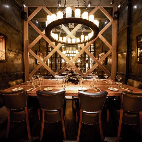 A rectangular table set up for a private event at Fazenda, with a circular light over the table