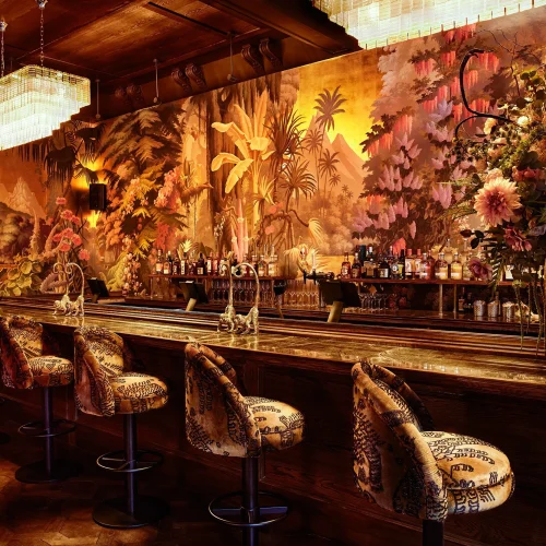 The bar at House of Gods, decorated with floral tapestries, and dark red colours