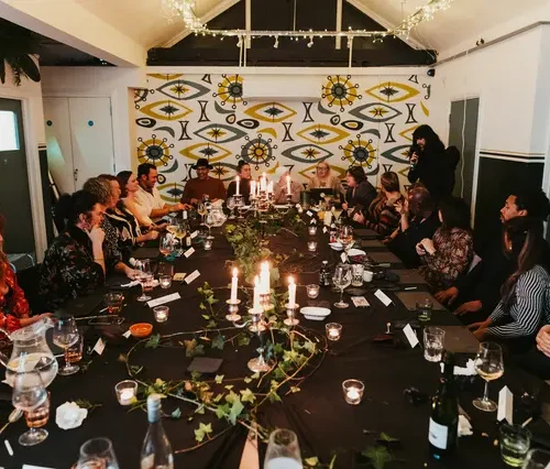 A table of people plying whodunit games at a Halloween party with HOMETAINMENT
