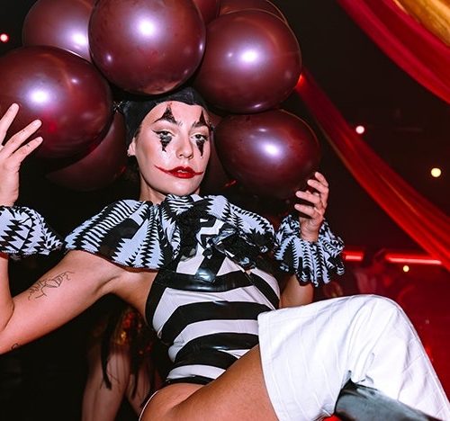 A performer dressed as a clown holding balloons for the Halloween celebration at Ministry of Sound