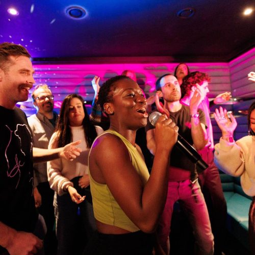 A party singing and dancing in their private karaoke booth at Lucky Voice