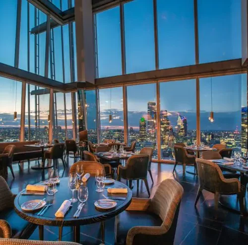 A view of the tables at Aqua Shard, which are surrounded by large windows providing a 360 view of the London skyline