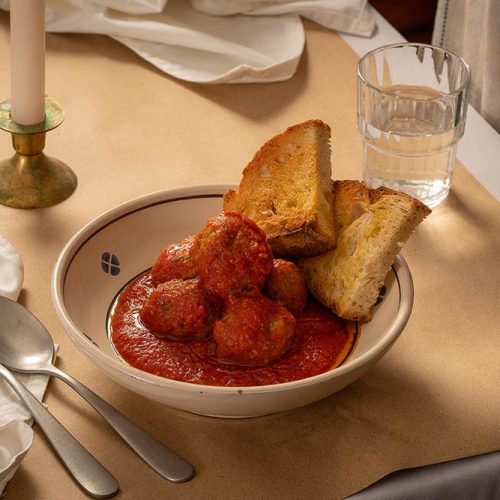 An Italian meatball dish served at Tiella Trattoria with a side of toasted bread