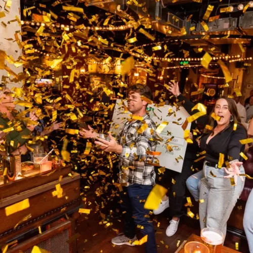 People celebrating the new year under golden confetti at Flight Club