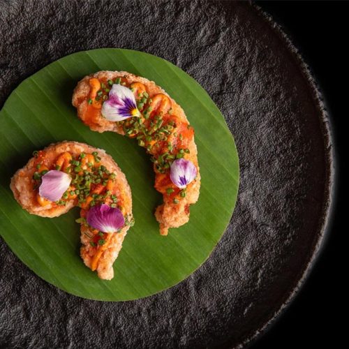 A dish served at Tresind, decorated with delicate flowers and served on a leaf