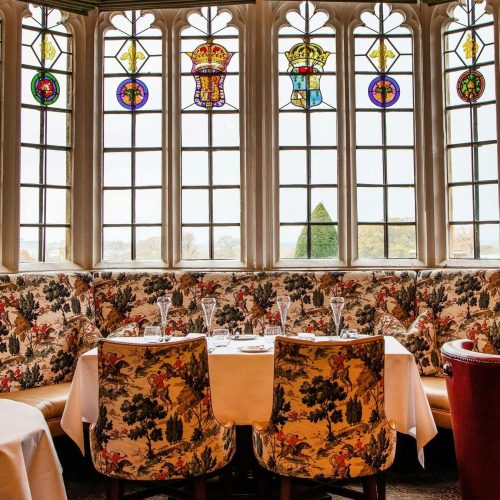 A seating area at Ellenborough Park, decorated with stained glass windows that look out onto the grounds