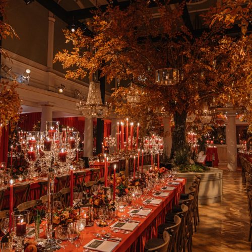 The Soane Hall at One Marylebone ready for a large event, decorated with a large tree and red tables