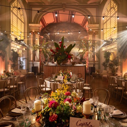 The Soane Hall in One Marylebone, ready for a large capacity event, decorated with flowers and yellow lighting