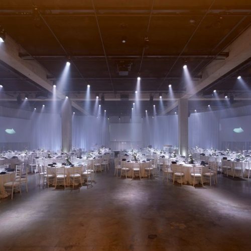 A large event set up in the Turbine Hall in the Tate Modern, with simple circular seating and spotlights