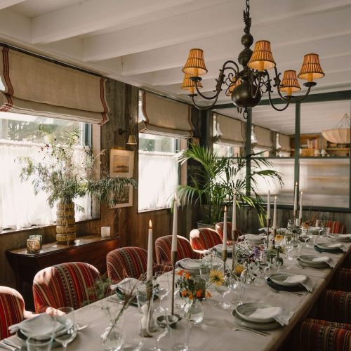 A private dining room at The Gallivant in Camber Sands, decorated with long candles and greenery