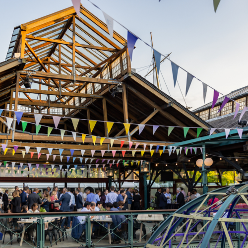 An outside event space at Tobacco Dock with bright bunting, perfect for a summer corporate party