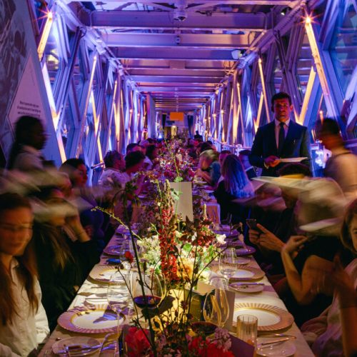 A busy party in Tower Bridge, with one long table that goes down the main event space