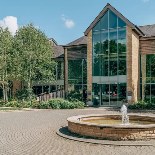 The entrance to De Vere Cotswold Water Park, decorated with a large fountain and driveway