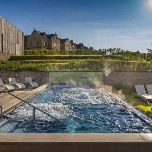 The outdoor pool at South Lodge, surrounded by deck chairs and the beautiful gardens