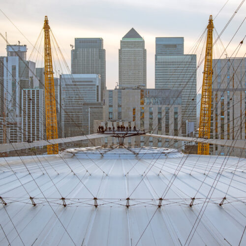 The top of the O2 with the London skyline in the background, with guests stood at the top, admiring the view