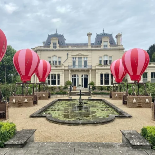 The Beaverbrook grounds in summer, decorated with the infamous hot air balloon tables around a pond