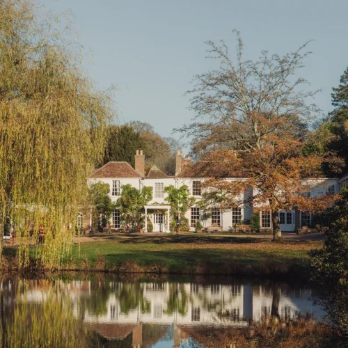 The view of Crafted at Powdermills from across the river, surrounded by willow trees and nature