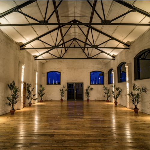 The main event space at Osea Island, which has large ceilings and visible beams, making it feel like a modern barn
