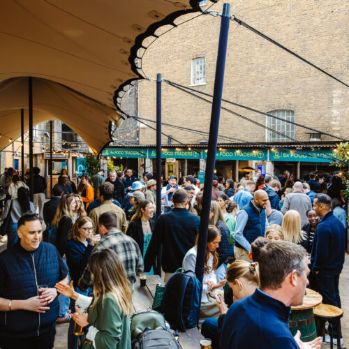 A large corporate party in Flat Iron Square, enjoying food and drinks in the courtyard