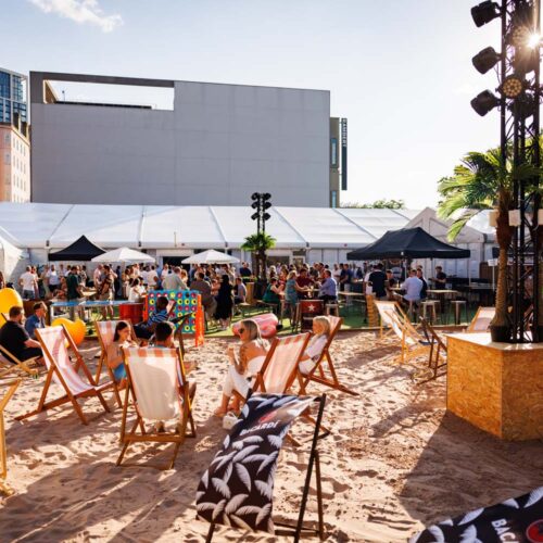 A corporate party at London City Beach, with guests enjoying the deck chairs and large outdoor areas