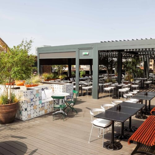 The main rooftop space at The Conduit, decorated with light furnishing and plants